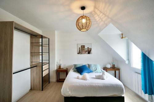 1 dormitorio con 1 cama grande con almohadas azules en La pointe de sel, en Trégunc