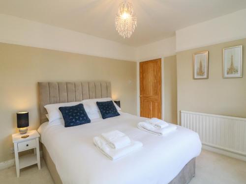 a bedroom with a large white bed with blue pillows at 148 Fairfield Road in Morecambe