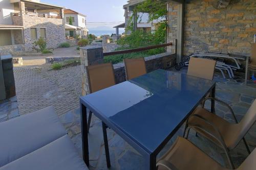 a blue table and chairs on a patio at Villa Ambrosia, beach house, Platanidia, Pelion in Platanidia