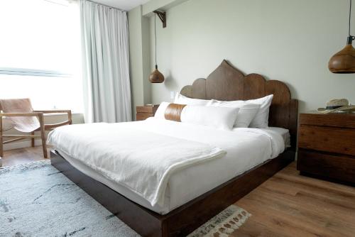 a bedroom with a large bed with a wooden headboard at CODA Williamsburg in Brooklyn