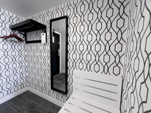 a bathroom with a black and white patterned wall at The Oceanside, a Coast Hotel in Sechelt