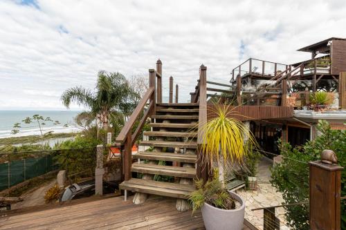 a staircase leading up to a house with the beach at Pousada Descanso do Rei - Vista Para o Mar & Melhor Localização da Praia do Rosa in Praia do Rosa