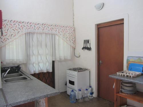 a kitchen with a sink and a stove top oven at Toad Tree Cabins in Sodwana Bay