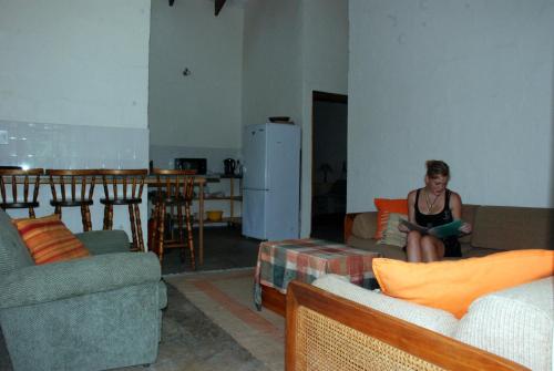 a woman sitting on a couch in a living room at Toad Tree Cabins in Sodwana Bay