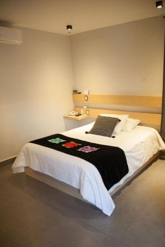 a bedroom with a large bed with a black and white blanket at Maria Ines Hotel Suite in Oaxaca City