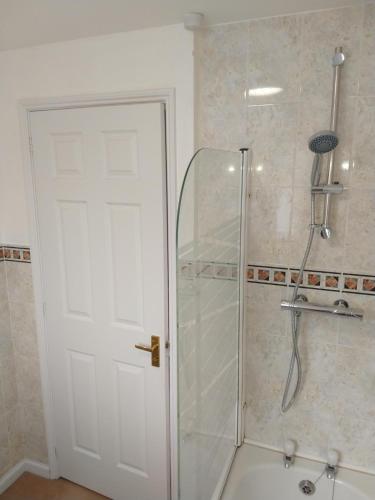 a shower with a glass door in a bathroom at Sunningdale homely detached family/contractor 3 bed house in Lincolnshire