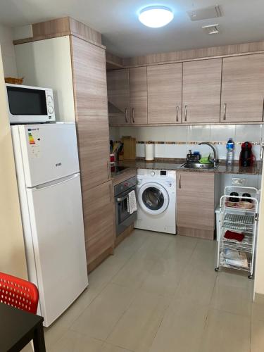 uma cozinha com um frigorífico branco e uma máquina de lavar louça em El Nostre em Deltebre