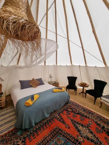 a bedroom with a bed in a yurt at Goodmuda Tipi's in Grândola