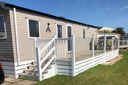 a mobile home with a porch and a deck at Tranquility No 42 Port Haverigg Marina in Millom