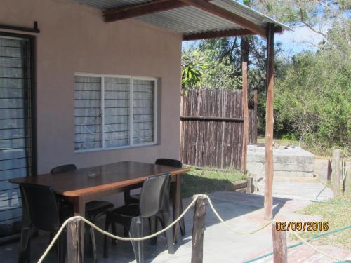 a table and chairs in front of a house at Toad Tree Cabins in Sodwana Bay