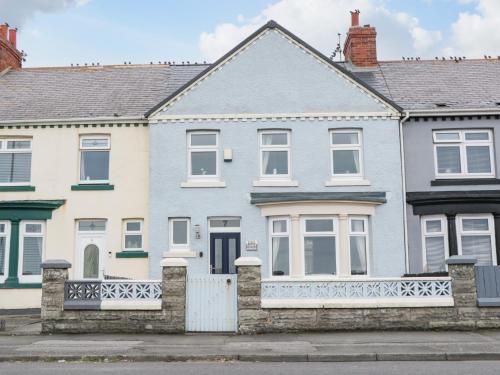 a blue and white house with a fence at 7 Marine Drive in Hartlepool