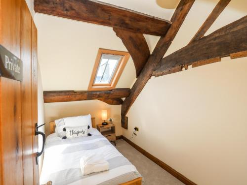 a bedroom with a bed and wooden beams at Above Deck in Beaumaris