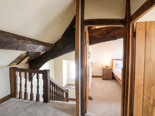 um quarto com uma escada e um quarto com vigas de madeira em Above Deck em Beaumaris