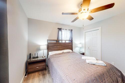a bedroom with a bed and a ceiling fan at Summer by the Sea in Waves