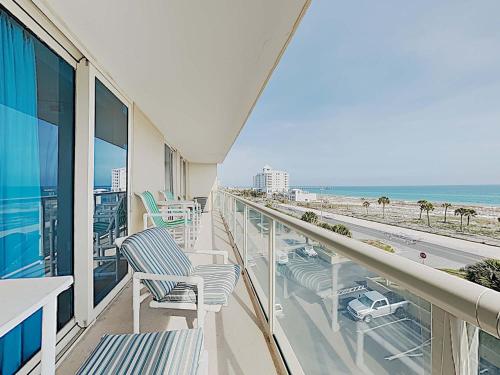 a balcony with chairs and a view of the beach at Sabine Yacht & Racquet #5E in Pensacola Beach