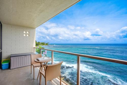 balcón con mesa, sillas y vistas al océano en Kuhio Shores 410 en Koloa