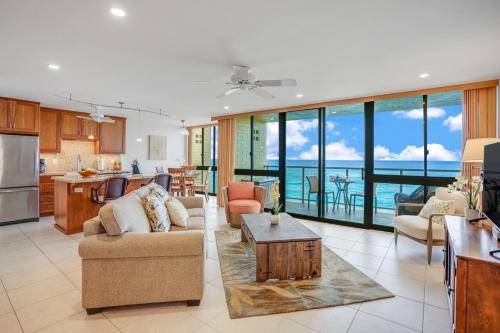 a living room and kitchen with a view of the ocean at Kuhio Shores 410 in Koloa