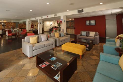 un vestíbulo con sofás, sillas y una mesa en San Agustin Exclusive, en Lima