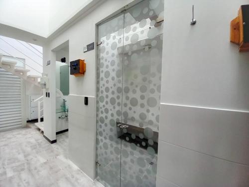 baño con ducha y puerta de cristal en Pontevedra Hotel Boutique, en Paipa