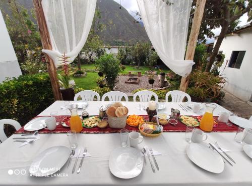 una mesa blanca con comida encima en The Willow B&B, en Urubamba