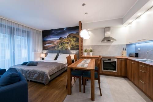 sypialnia z łóżkiem i stołem oraz kuchnia w obiekcie EXCLUSIVE Aparthotel we Wrocławiu