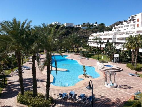 einen Blick über einen Pool mit Palmen und Gebäuden in der Unterkunft Mediterranean Sweet Home Mojacar in Mojácar