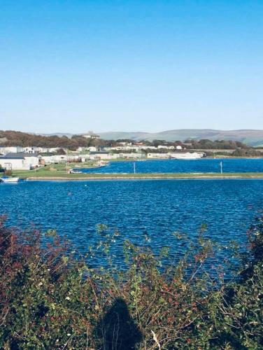 a large body of blue water with buildings in the background at Tranquility No 42 Port Haverigg Marina in Millom