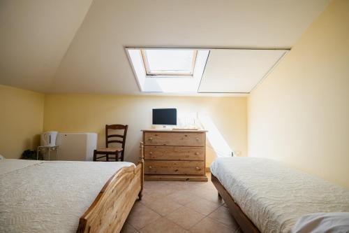 a bedroom with two beds and a dresser with a window at L'Incanto dei Sibillini in Cessapalombo
