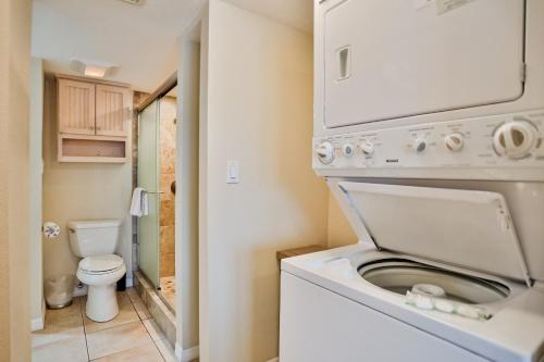 a small bathroom with a washer and dryer at Dockside Destiny in St. Pete Beach