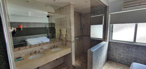 a bathroom with two sinks and a large mirror at Hotel Venus in Buenos Aires