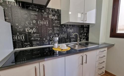 a kitchen with a black wall with drawings on it at Imeda Apartamentos Escudo del Carmen 19 in Granada