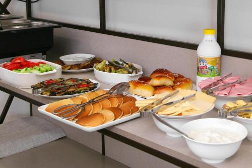 a buffet with plates of food and bowls of food at Bonjour Boutique Hotel Yerevan in Yerevan
