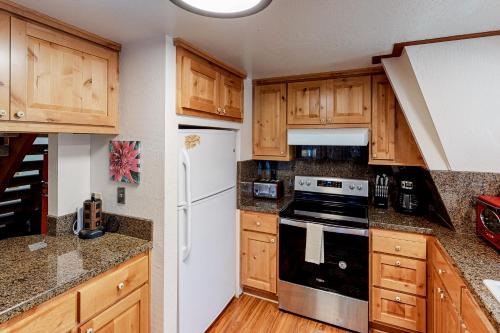 a kitchen with wooden cabinets and a white refrigerator at Chapel Grove in Tahoe City