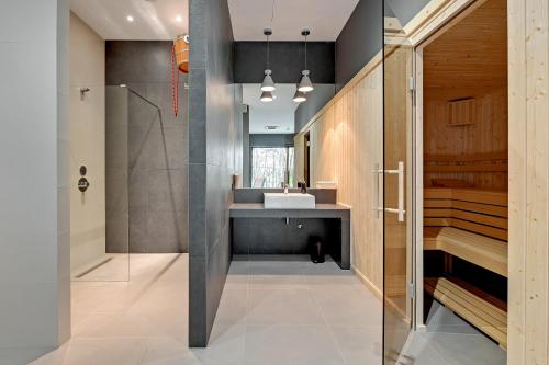 a bathroom with a sink and a shower at Seaside Apartments Baltica Tower with Gym, Sauna & Parking in Gdańsk