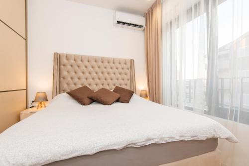 a bedroom with a white bed with a large window at Apartment Odysseus in Tivat