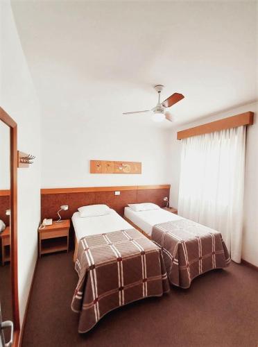 a room with two beds and a window in it at Union Residence - HEER in Novo Hamburgo