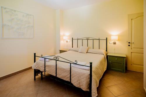 a bedroom with a bed and two night stands and a door at L'Incanto dei Sibillini in Cessapalombo