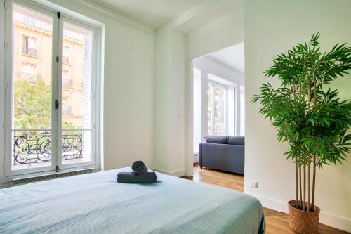- une chambre avec un lit et deux plantes en pot dans l'établissement Appartement Quartier Chatelet Les Halles Free Netflix, à Paris