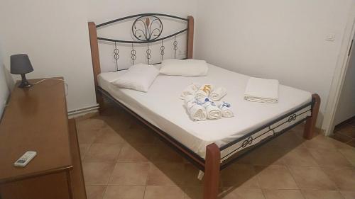 a bed with white sheets and towels on it at Το πετρινο in Agia Marina Mikrolimanou