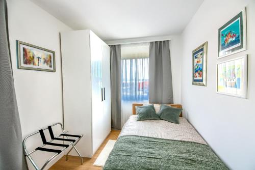 a small bedroom with a bed and a chair at Apartman Eva, moderan stan u srcu Zagorja in Krapina