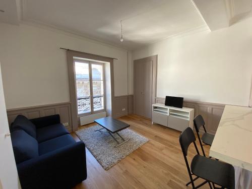 een woonkamer met een blauwe bank en een bureau bij Location dans le Grand Hotel d'Aix les bains in Aix-les-Bains