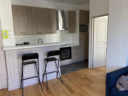 une cuisine avec deux tabourets sur un comptoir de cuisine dans l'établissement Location dans le Grand Hotel d'Aix les bains, à Aix-les-Bains