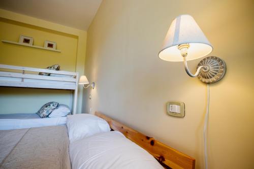 a room with two beds with a lamp and a fan at L'Incanto dei Sibillini in Cessapalombo