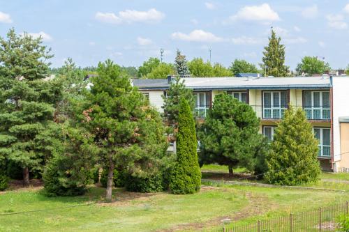 an apartment building with trees in front of it at Pokoje Relax Ostrołęka in Ostrołęka