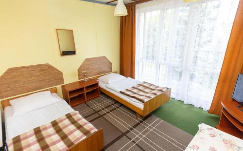 een kamer met 2 bedden en een raam bij Pokoje Relax Ostrołęka in Ostrołęka