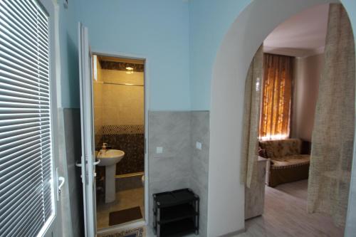ein Badezimmer mit einem Waschbecken, einem WC und einem Spiegel in der Unterkunft Guest House Nise in Tbilisi City