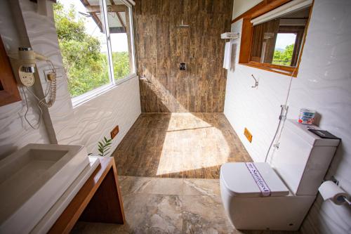 a small bathroom with a toilet and a shower at Kalu's Hideaway Udawalawe in Udawalawe