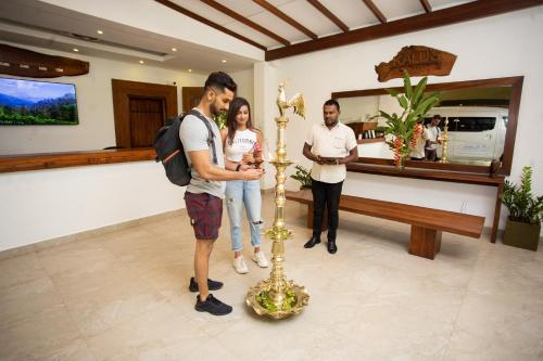 a group of people standing next to a gold candlestick at Kalu's Hideaway Udawalawe in Udawalawe