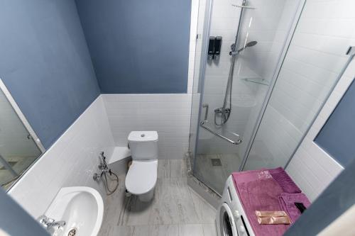 ein Bad mit einer Dusche, einem WC und einem Waschbecken in der Unterkunft КОРКЕМ НА МАНГИЛИК in Astana