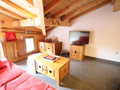 un salon avec un canapé et une télévision à écran plat dans l'établissement Appartement récent, 3e étage, exposé Sud-Est, à 10mn des pistes, balcon, parking et casier à skis - FR-1-623-199, aux Gets